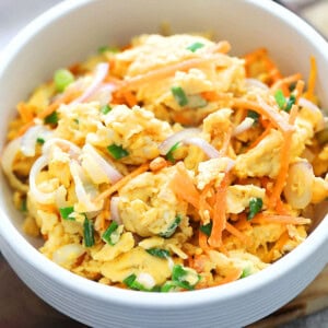 Chinese scrambled eggs with carrots, onions, and scallions served in a bowl.
