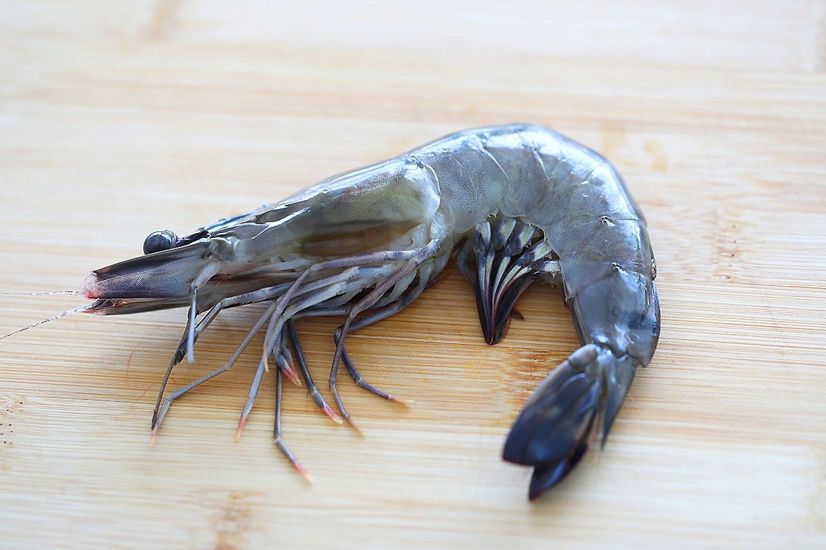 Large shrimp on a chopping board.