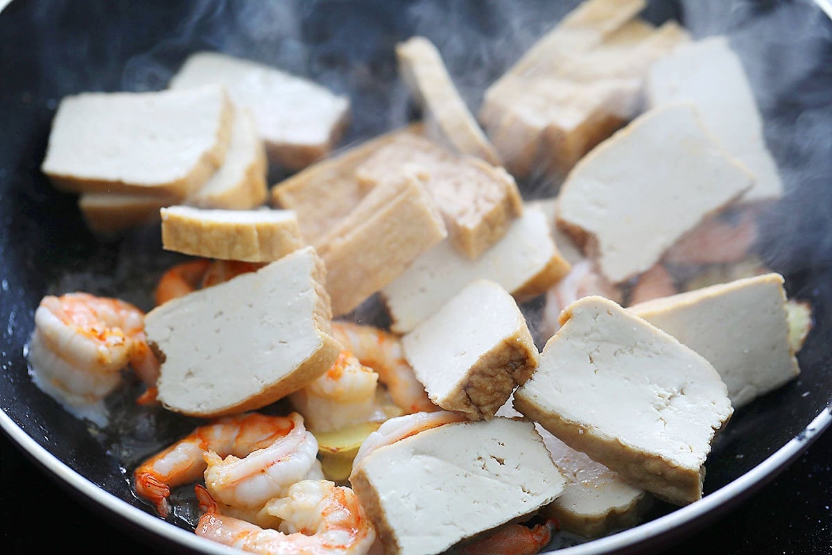 Fried tofu and shrimp in a pan.