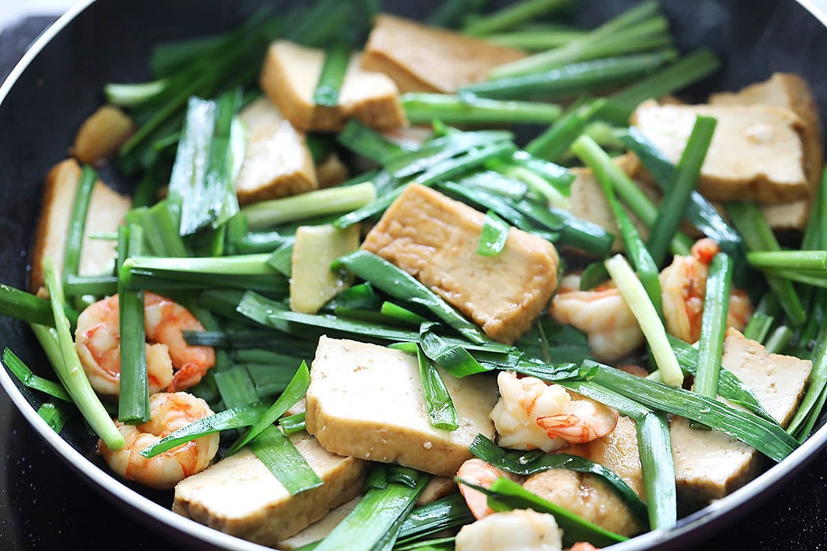 Tofu stir fry with chives and shrimp in a pan.