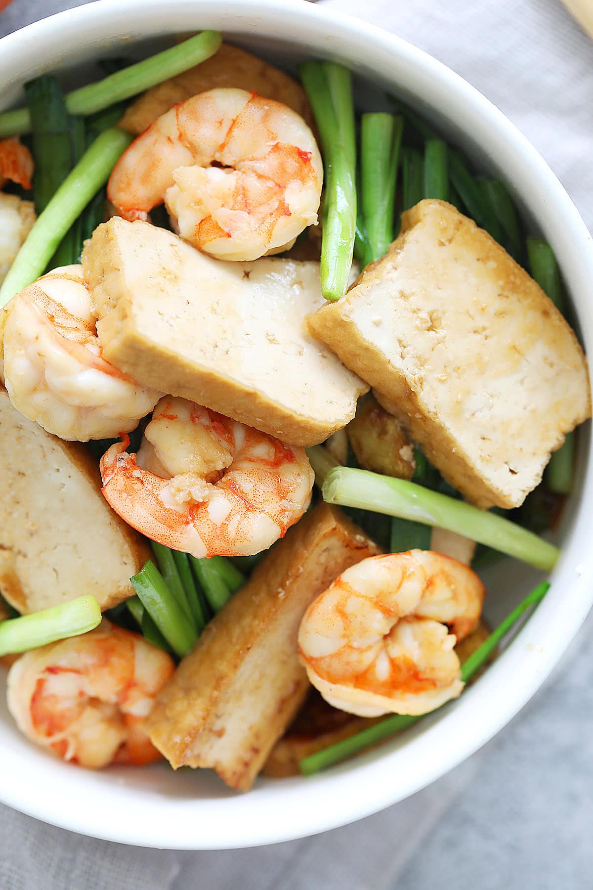 Chinese tofu stir fry with vegetables and shrimp in a bowl.