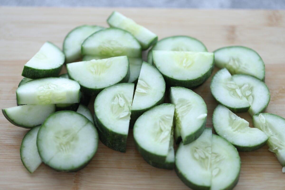 Cucumber slices on a chopping board.