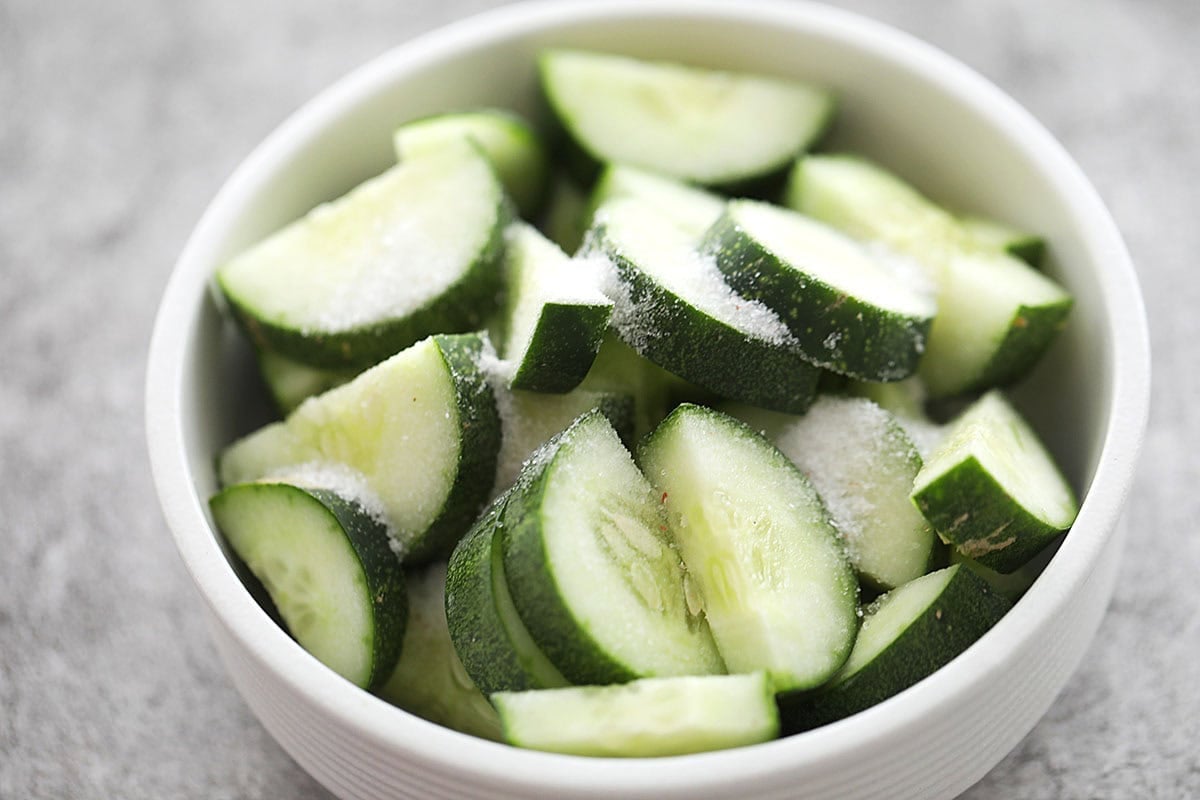 Cucumber slices and salt in a bowl.