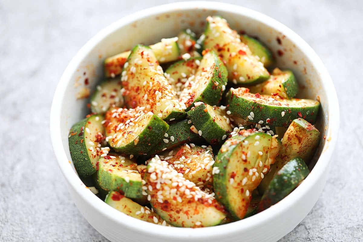 Crunchy and spicy Asian cucumber salad garnished with white sesame seeds.