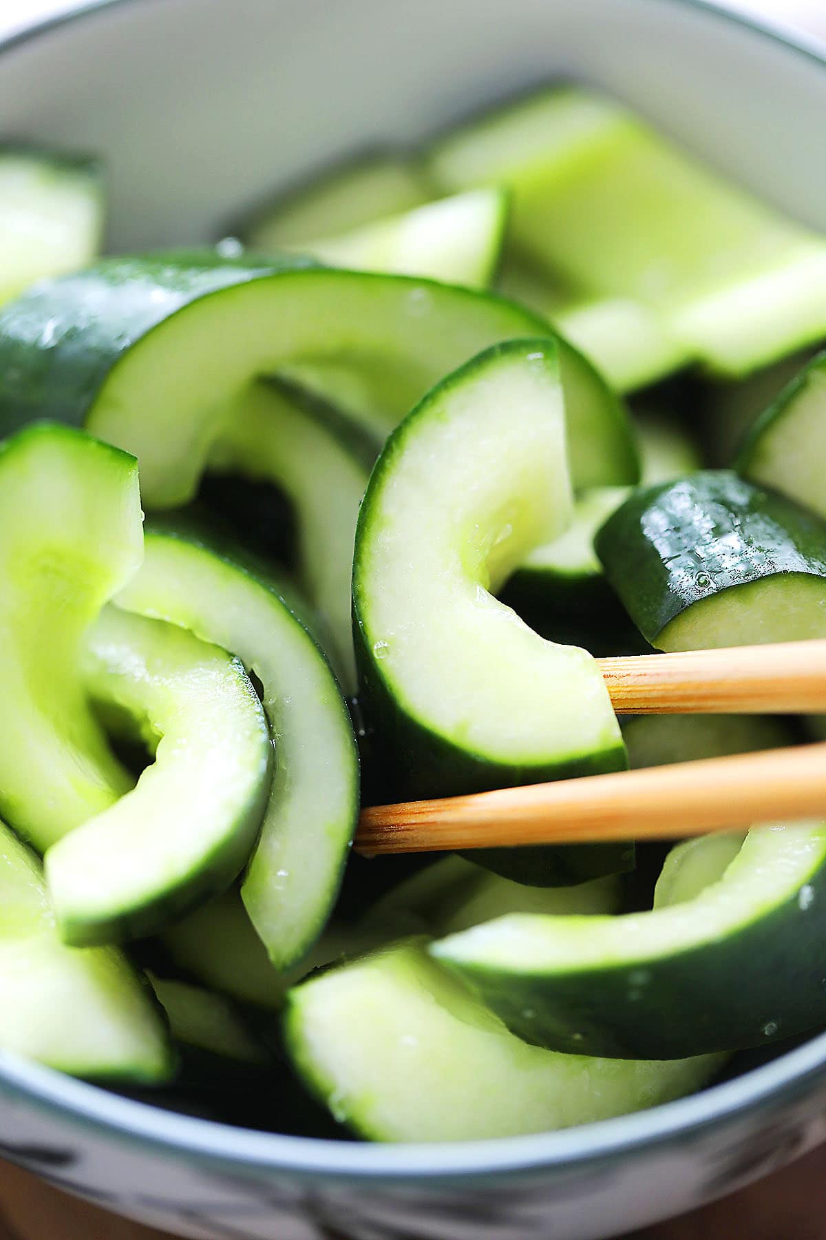 Cold Chinese cucumber salad picked up with a pair of chopsticks.
