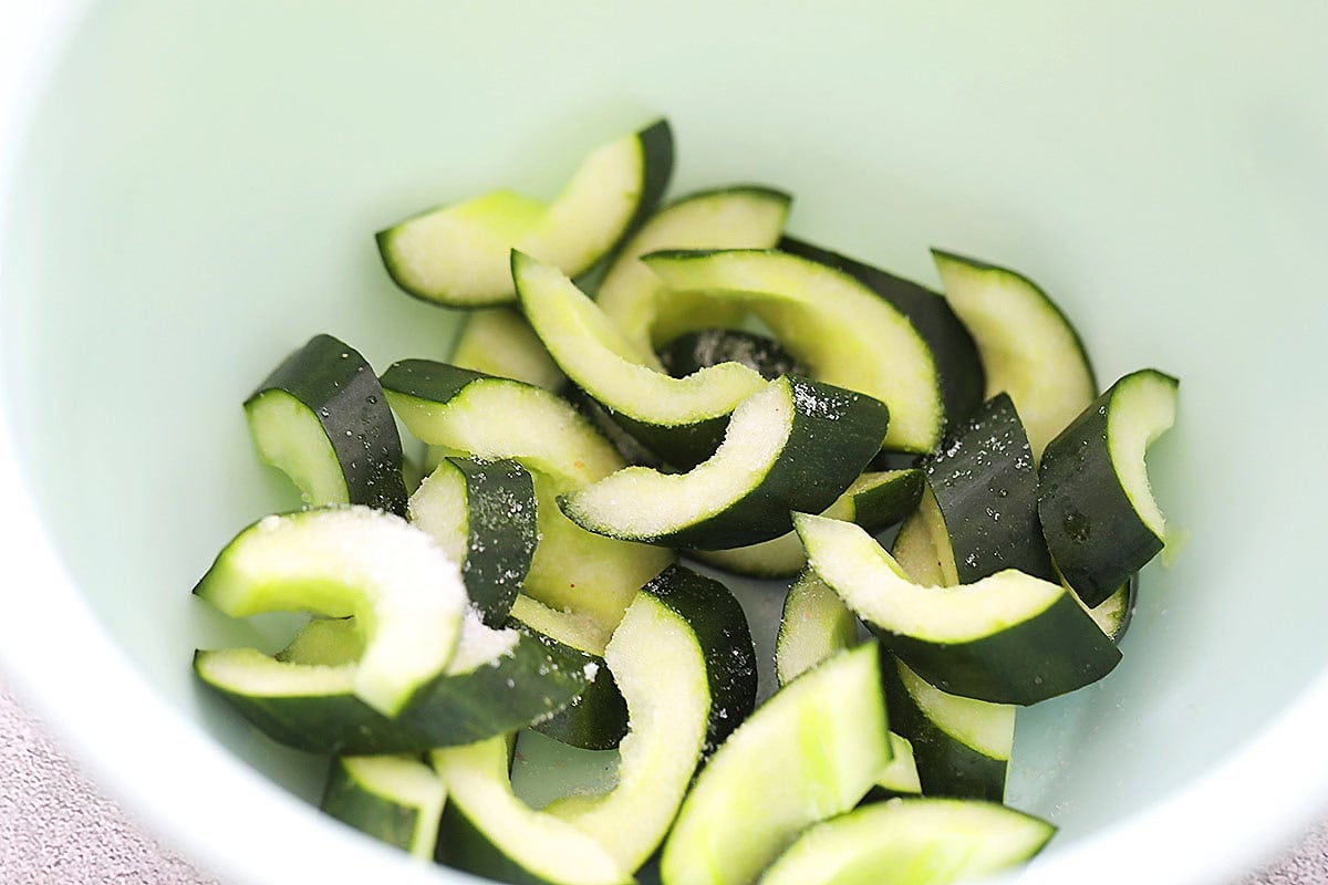 Cucumber slices and salt in a bowl.