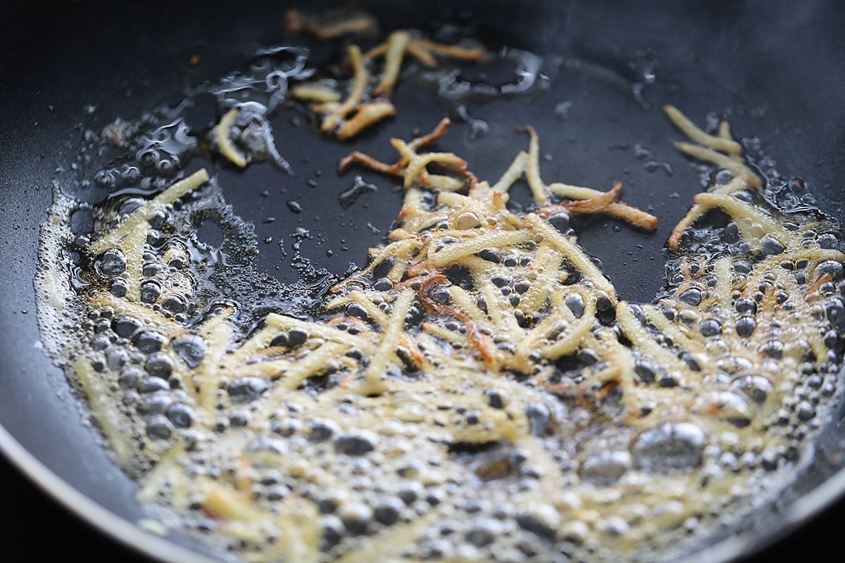 Golden brown ginger strips in a bowl.