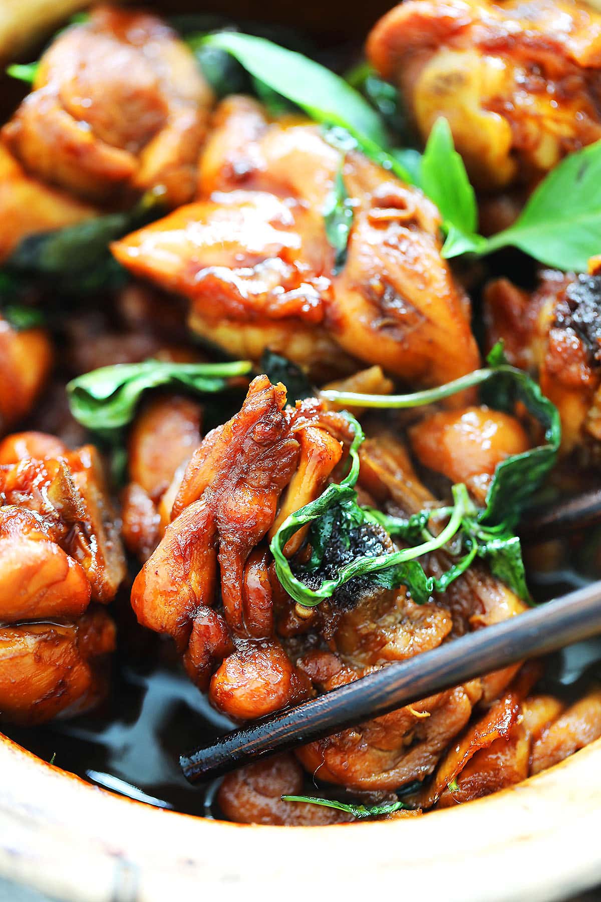 Homemade Three Cup Chicken in a clay pot with fragrant basil and caramelized sauce, an authentic Taiwanese comfort food.