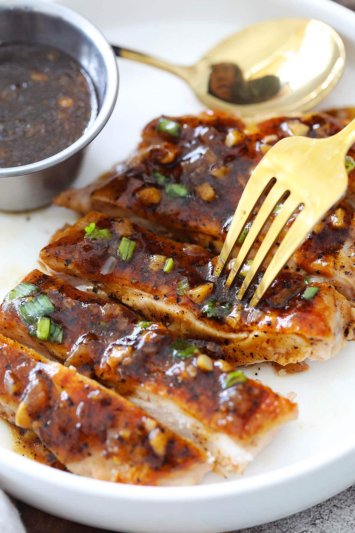 Chinese black pepper chicken made with a boneless chicken cutlet, pierced with a fork.