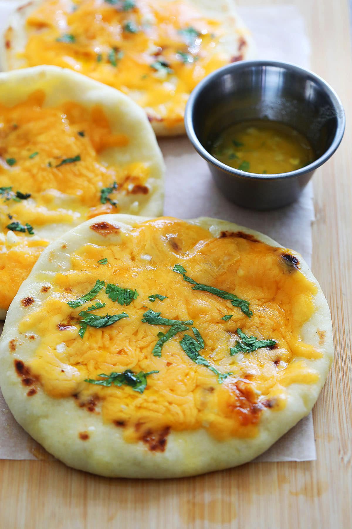 Garlic cheese naan served alongside garlic butter.