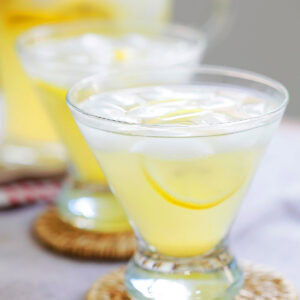 Easy lemon drop martini cocktail with vodka, lemon juice, triple sec sugar and ice in cocktail glasses.