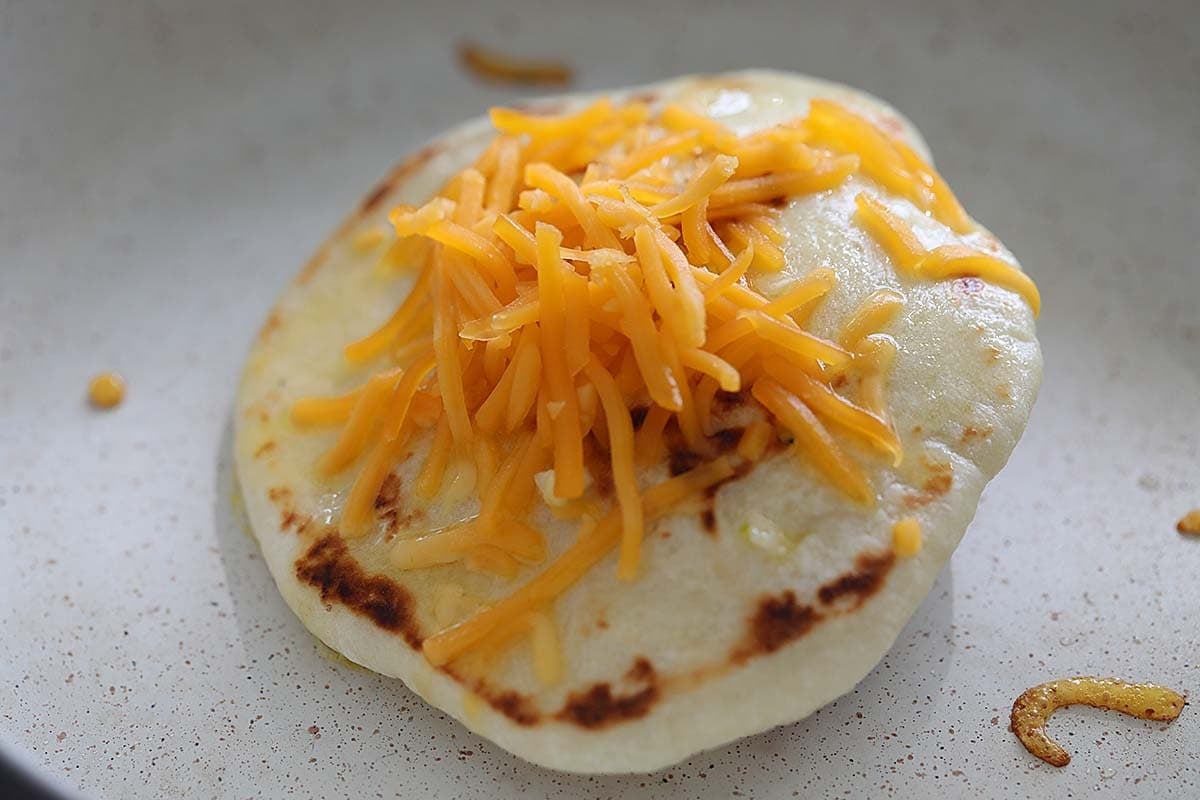 Naan topped with shredded cheddar cheese.