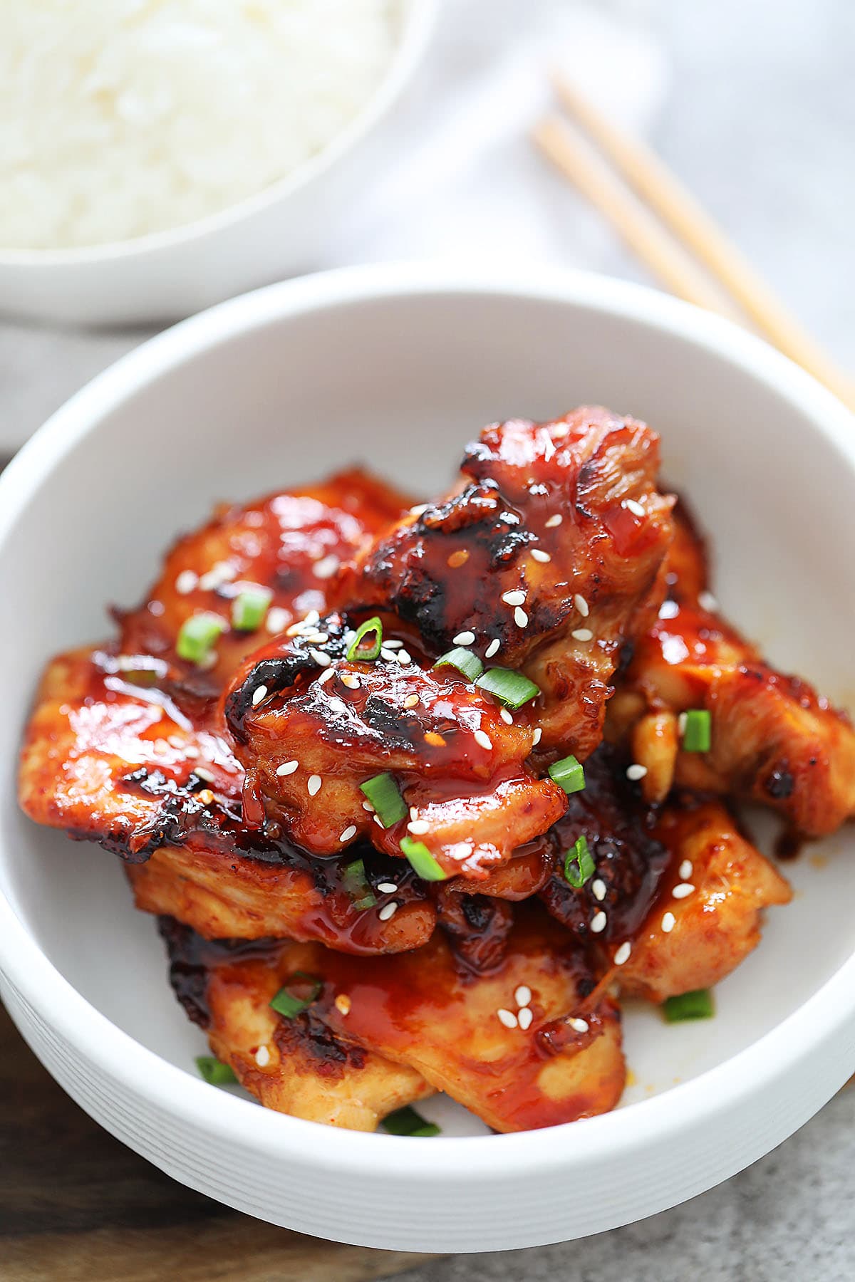 Spicy Korean chicken with spicy Gojuchang marinade garnished with scallions and sesame seeds.