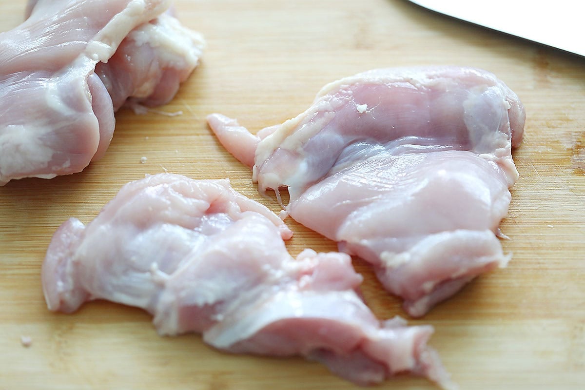 Chicken thighs on a cutting board.