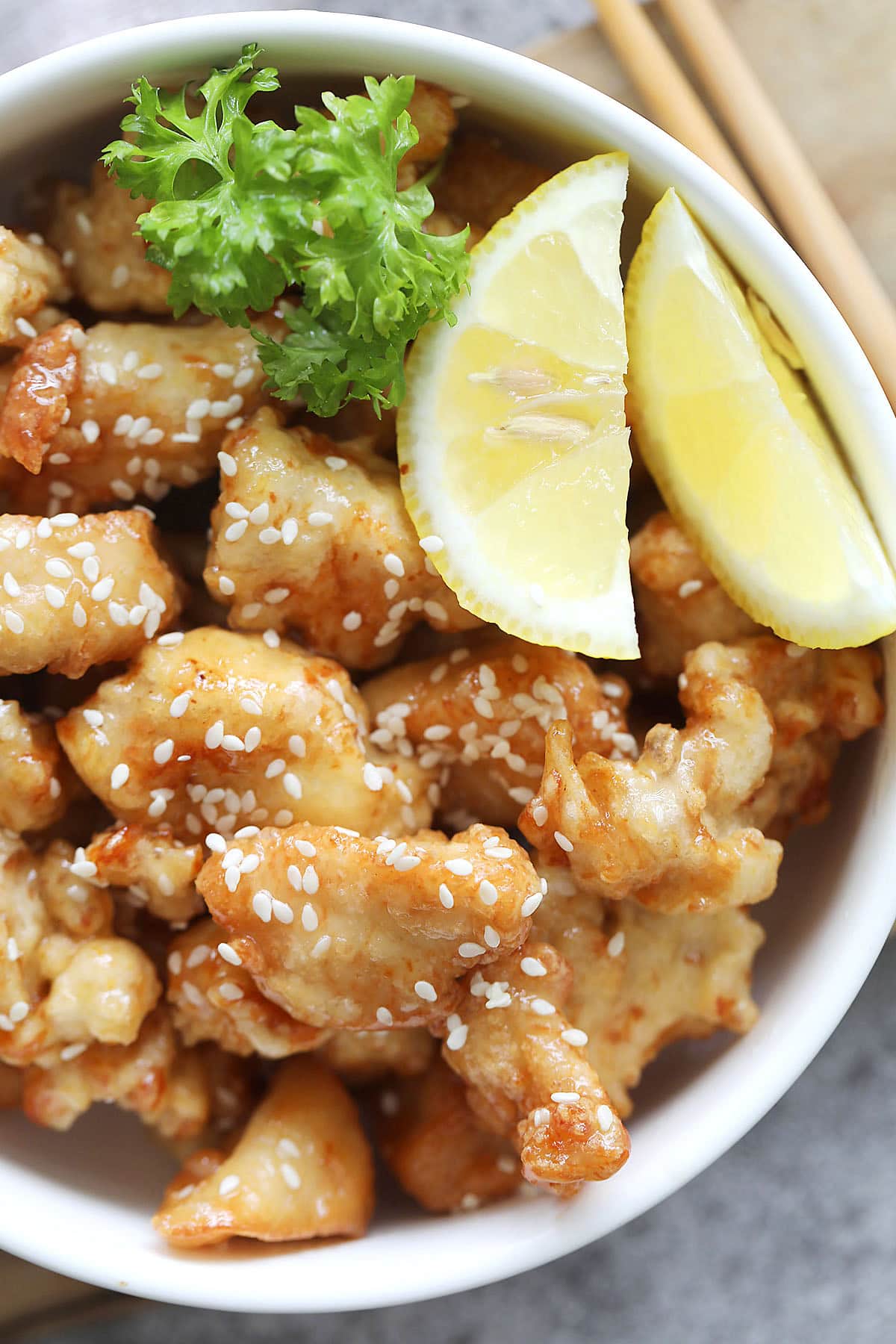 Chinese lemon chicken served with lemon wedges.