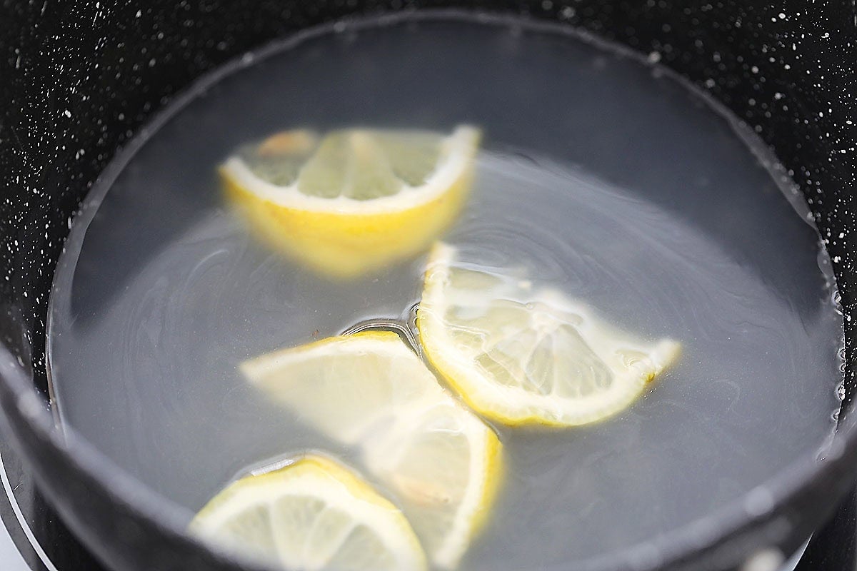 Homemade Chinese lemon sauce with lemon slices in a pot.