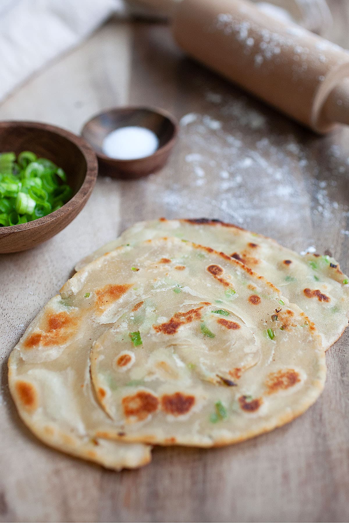 Chinese scallion pancakes on a wooden board.
