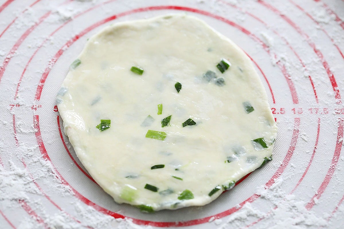 Raw scallion pancake on a silicon pad.