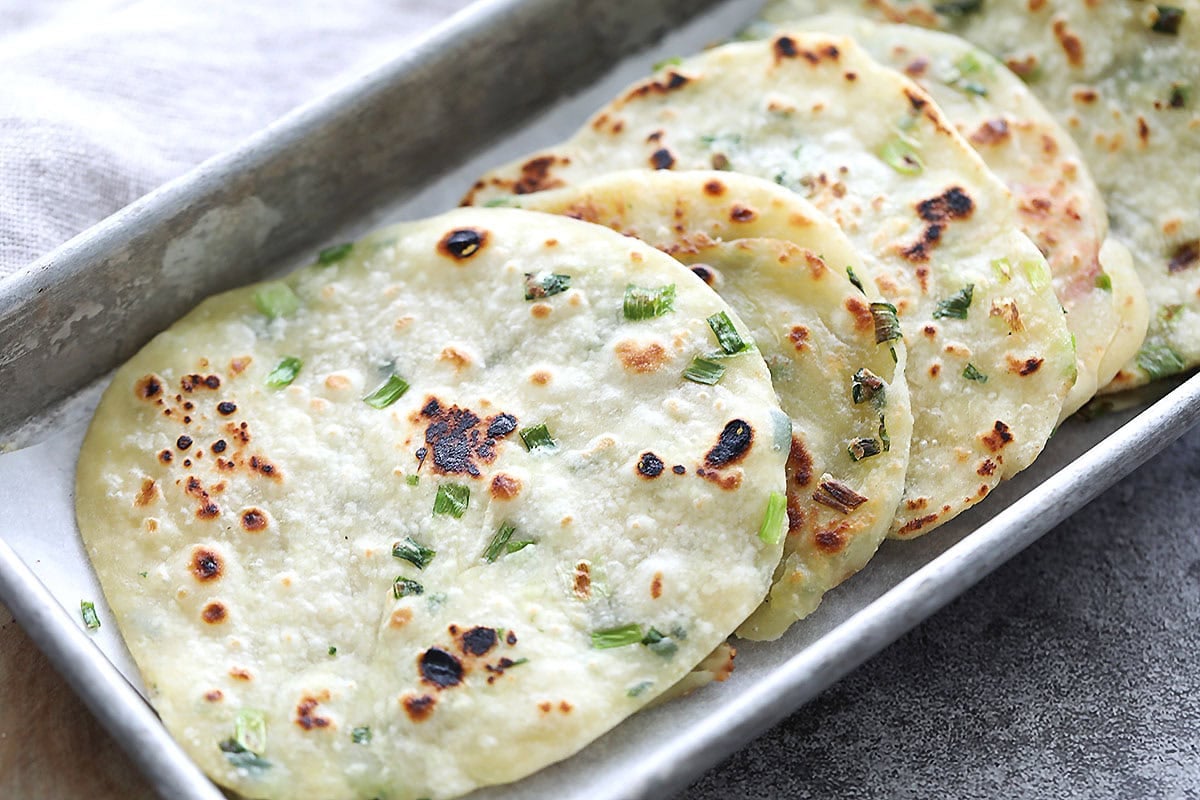Crispy Chinese scallion pancakes in a tray.