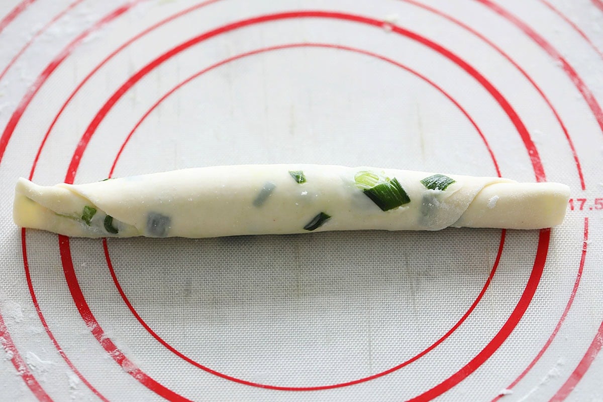 Rolled scallion pancake dough on a silicon mat.