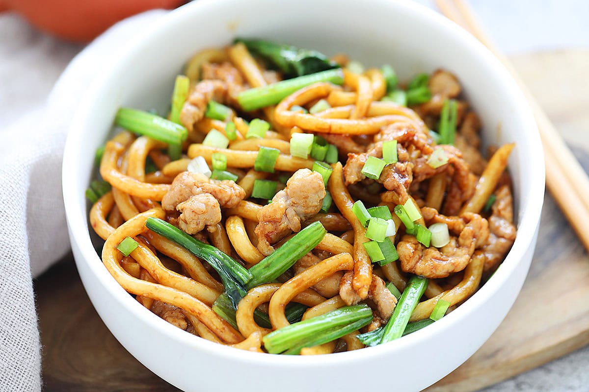 Shanghai style noodles recipe with pork and spinach served in a bowl.