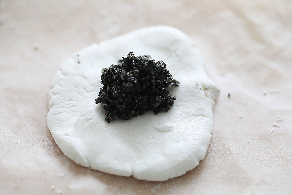 Black sesame filling on flatten tang yuan dough.