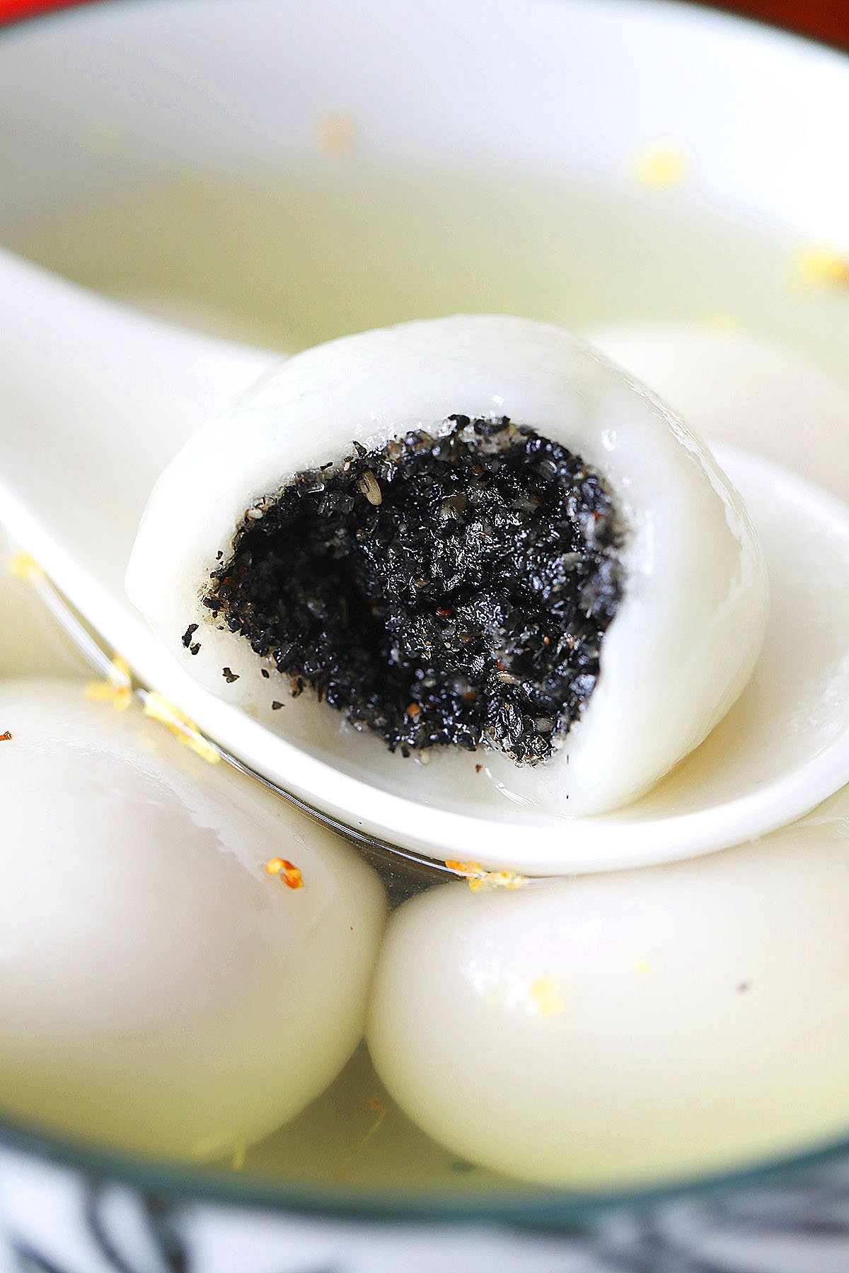 Easy and quick homemade black sesame tang yuan in half picked with a spoon.
