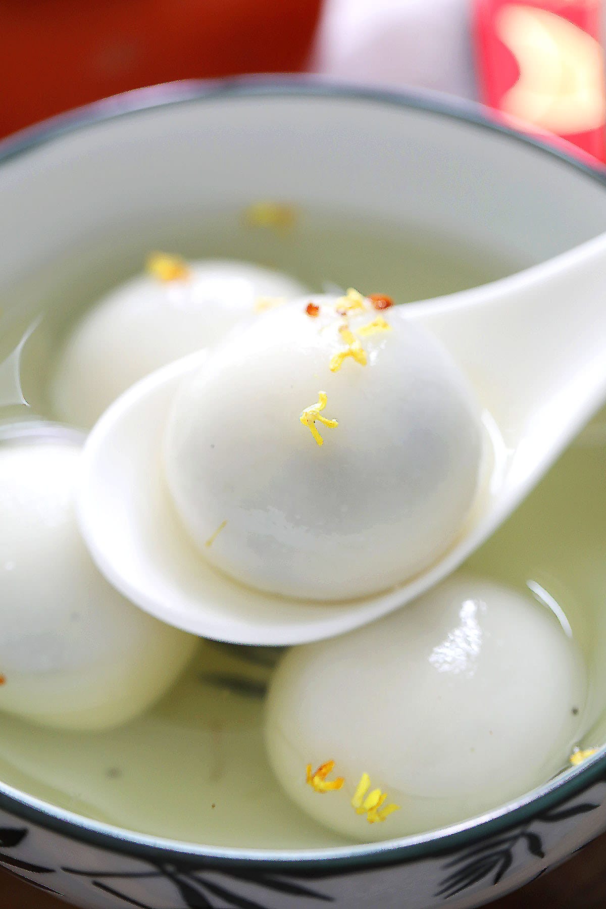 Tang yuan with sesame filling on a spoon.