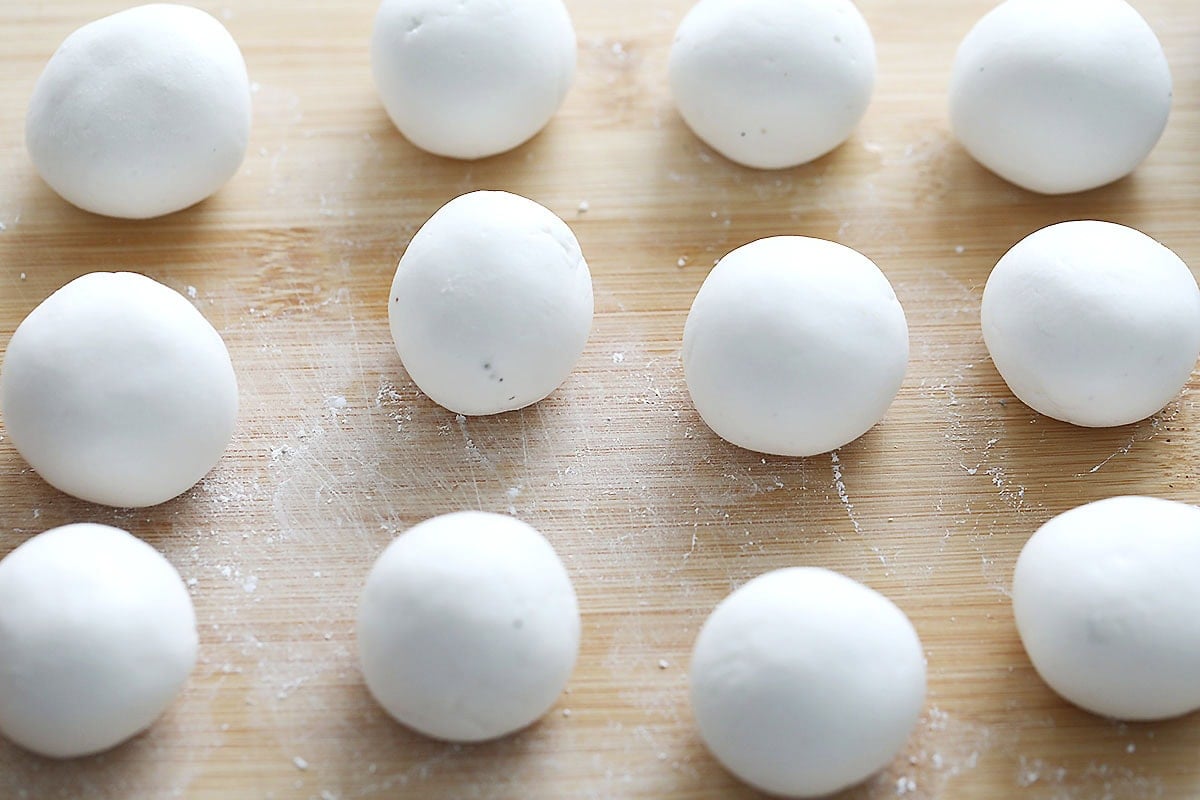Uncooked peanut tang yuan on a board.