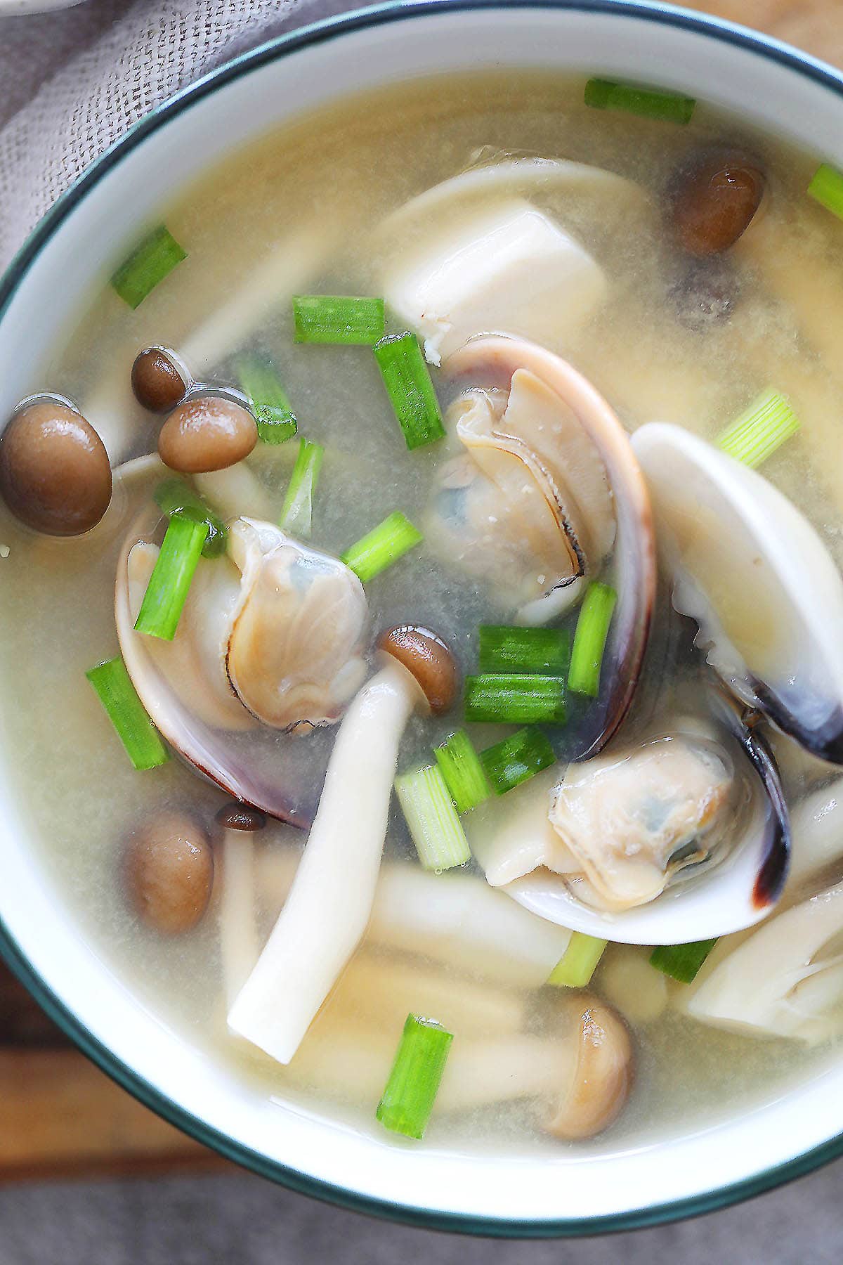 Miso soup with clams and buna shimeji mushrooms served in a bowl.