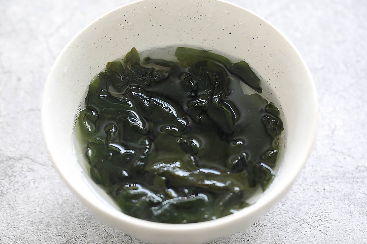 Wakame seaweed in a bowl of warm water.