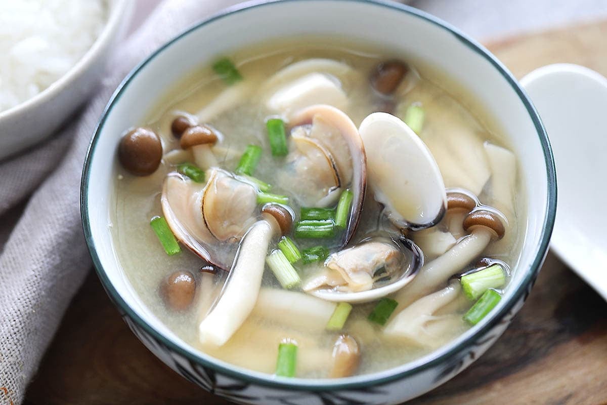 Miso clam soup garnished with scallions.