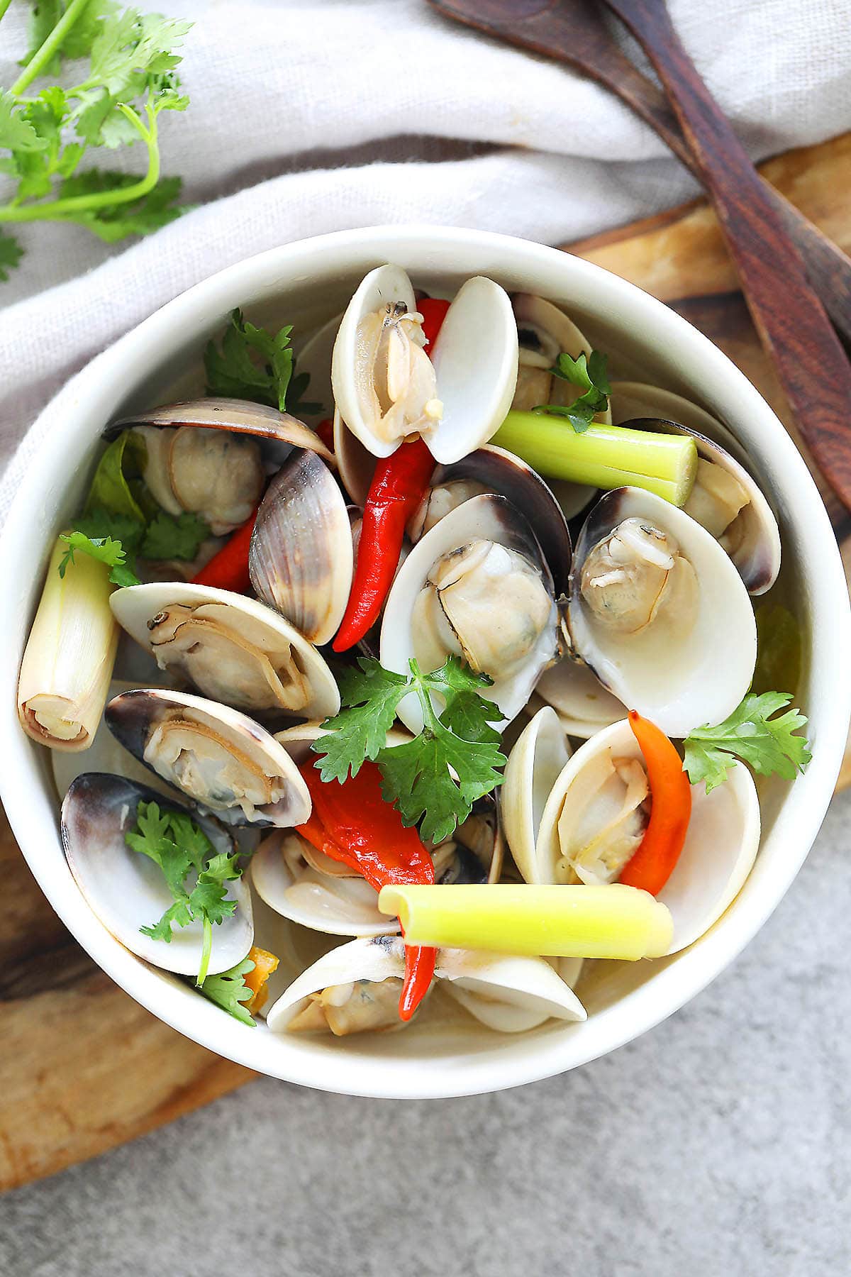 Thai steamed clams with lemongrass and coconut water served in a bowl.