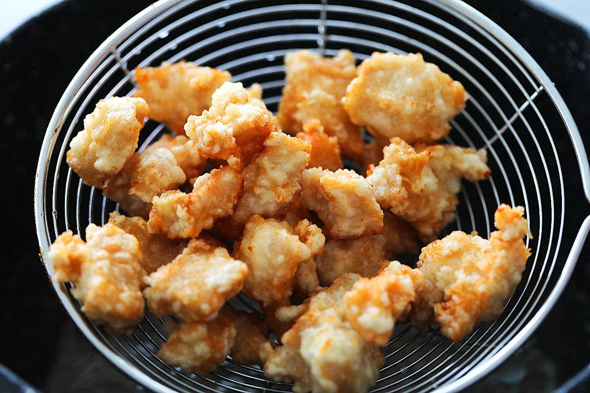Crispy fried chicken on a strainer.