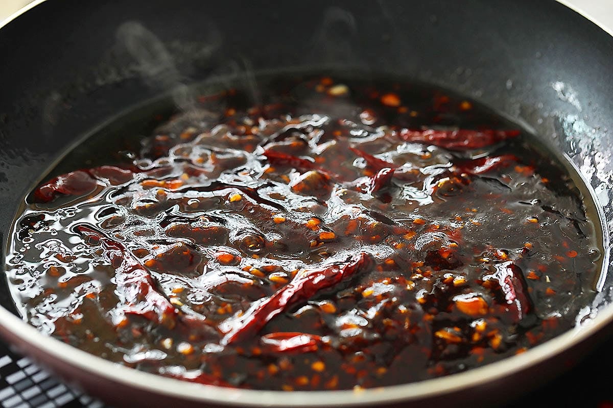 General Tso sauce and dried red chilies in a skillet.