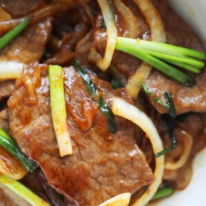 Scallion beef stir-fry with onion served in a bowl.