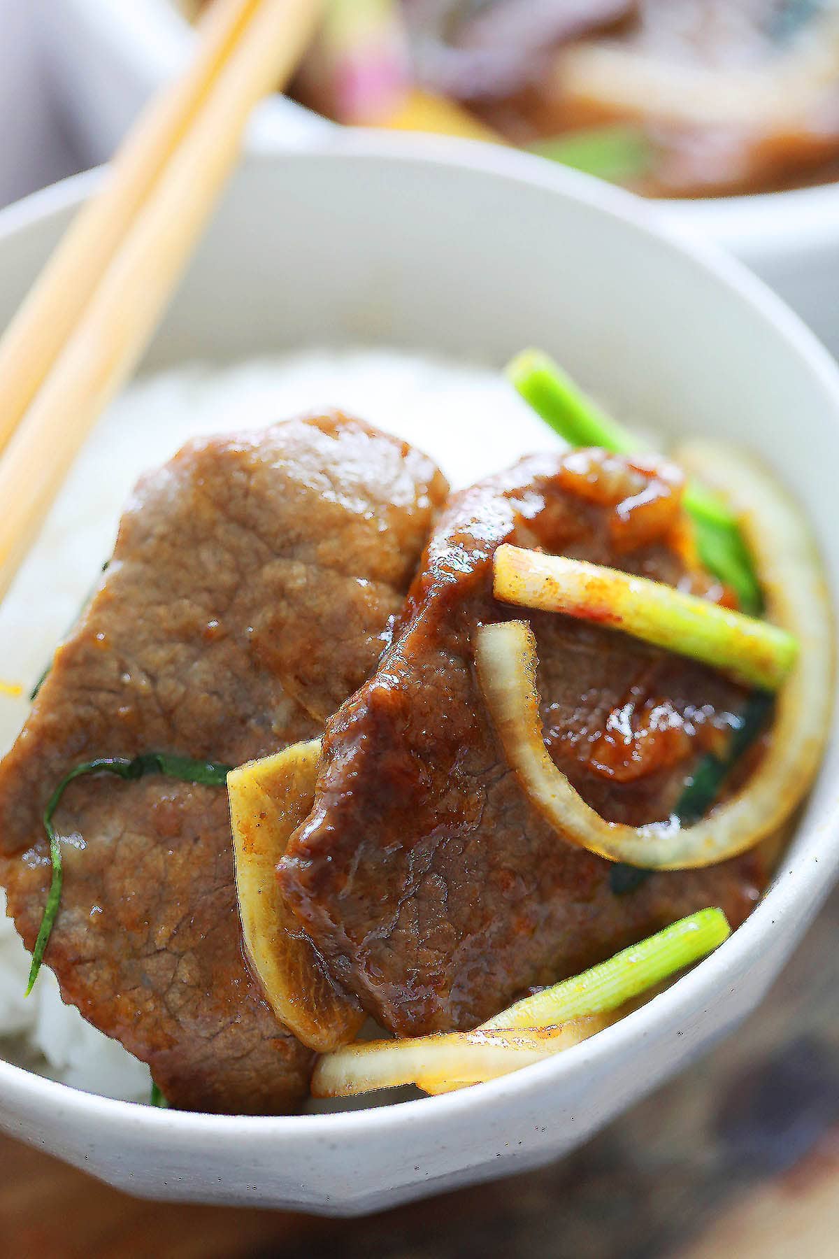 Onion scallion beef served with a bowl of rice.