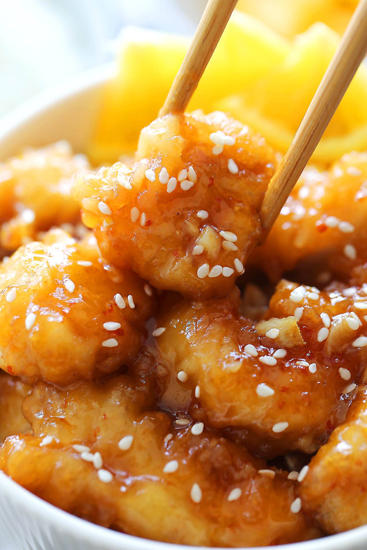 Chinese orange chicken picked with a pair of chopsticks.