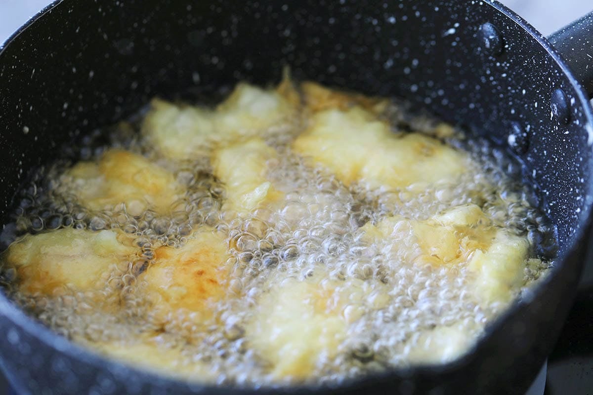 Chicken being deep fried in a pot.