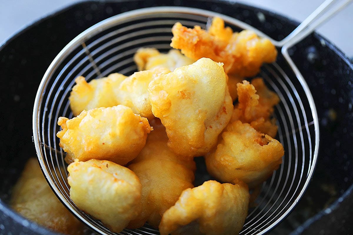 Light and crispy fried chicken on a strainer.