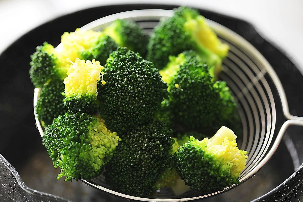 Blanched broccoli on a strainer.