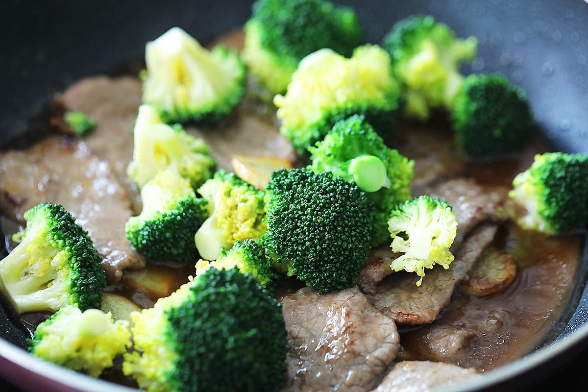 Broccoli, beef, and Chinese brown sauce in a pan.