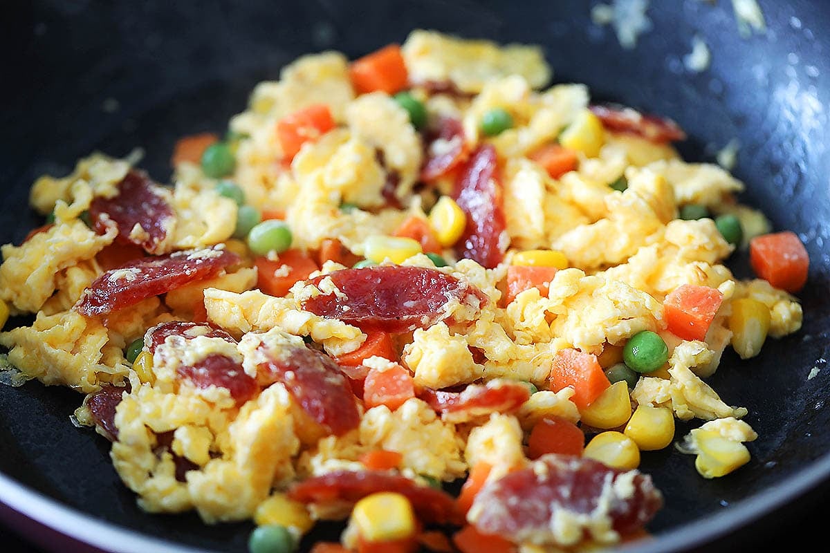 Chinese sausage, eggs, and mixed vegetables in a pan.