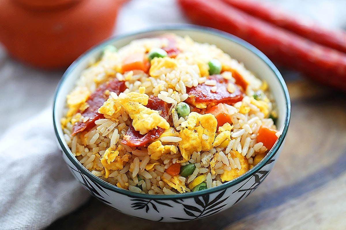 Restaurant style Chinese fried rice with eggs and Chinese sausage, served in a bowl.
