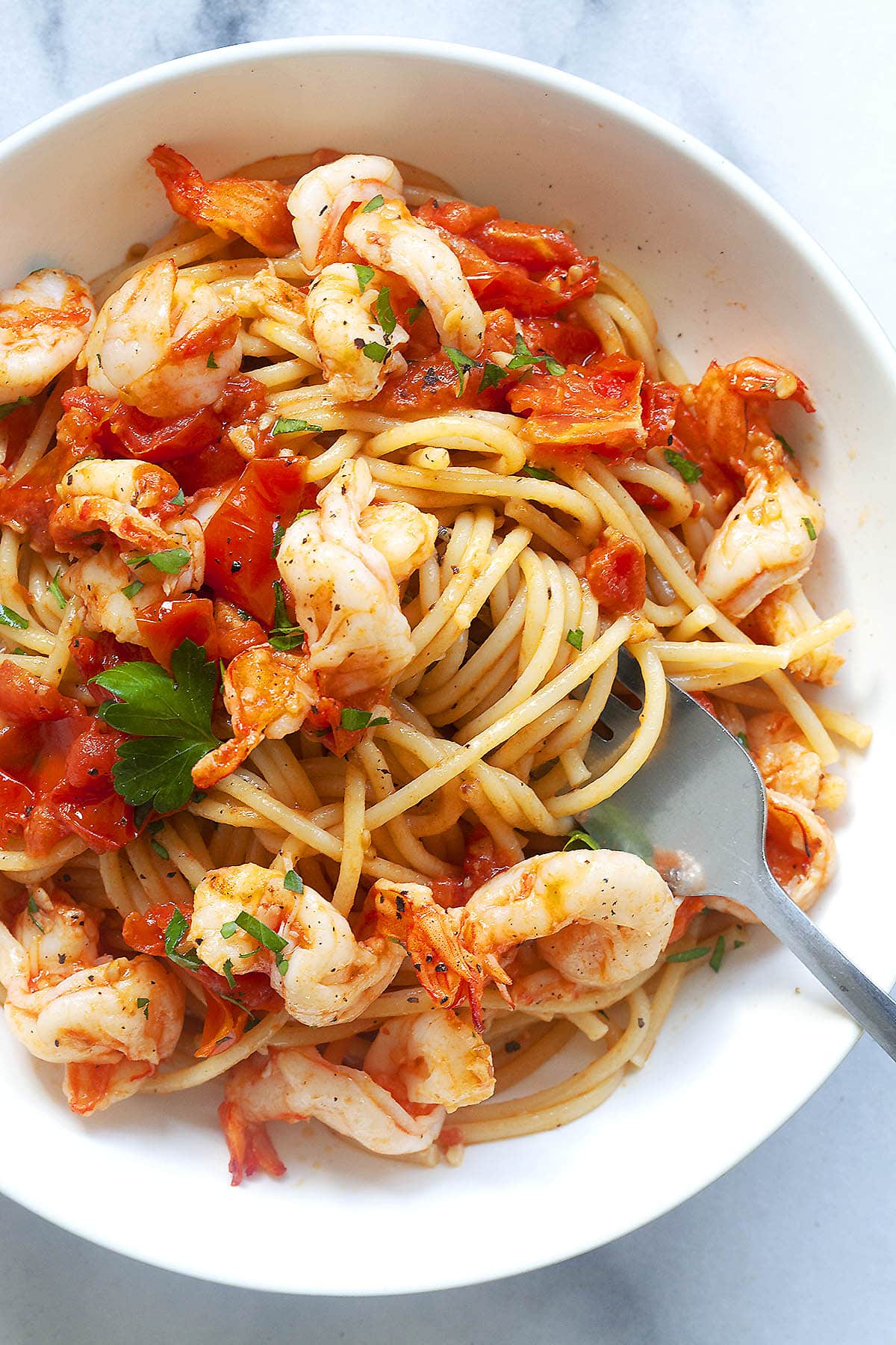 Red sauce Italian shrimp pasta served on a plate.