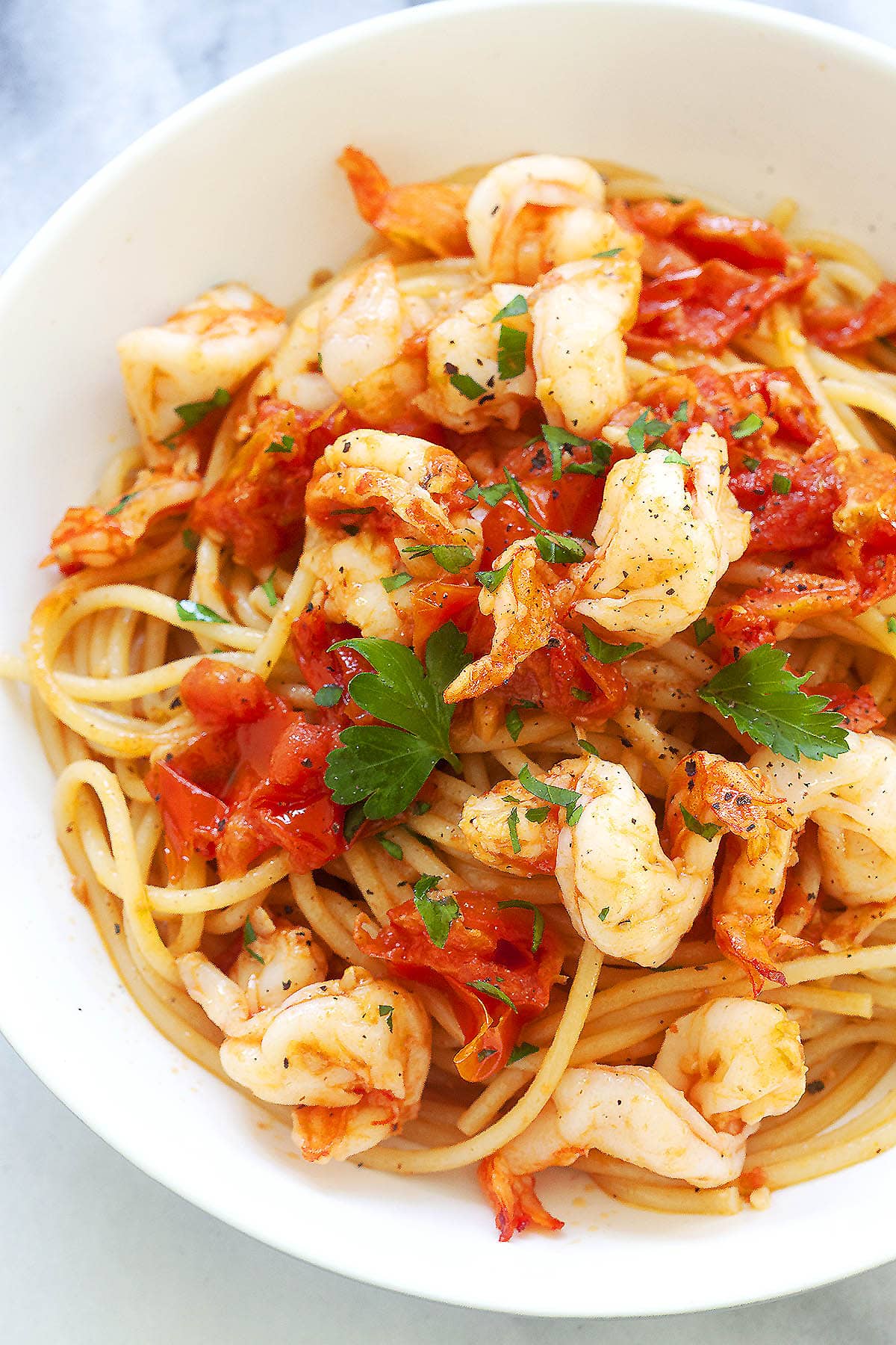 Italian shrimp pasta garnished with parsley, served on a plate.