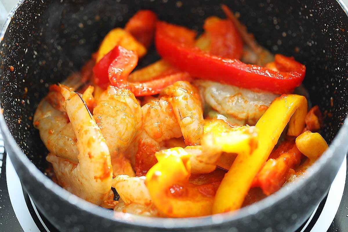 Shrimp and bell peppers in a saucepan.