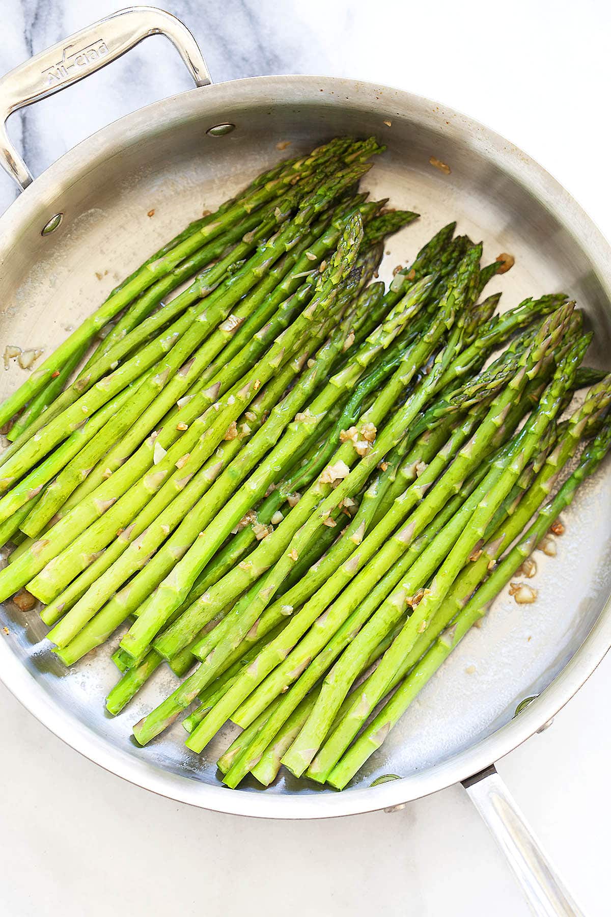 Pan seared sauteed asparagus in a skillet.