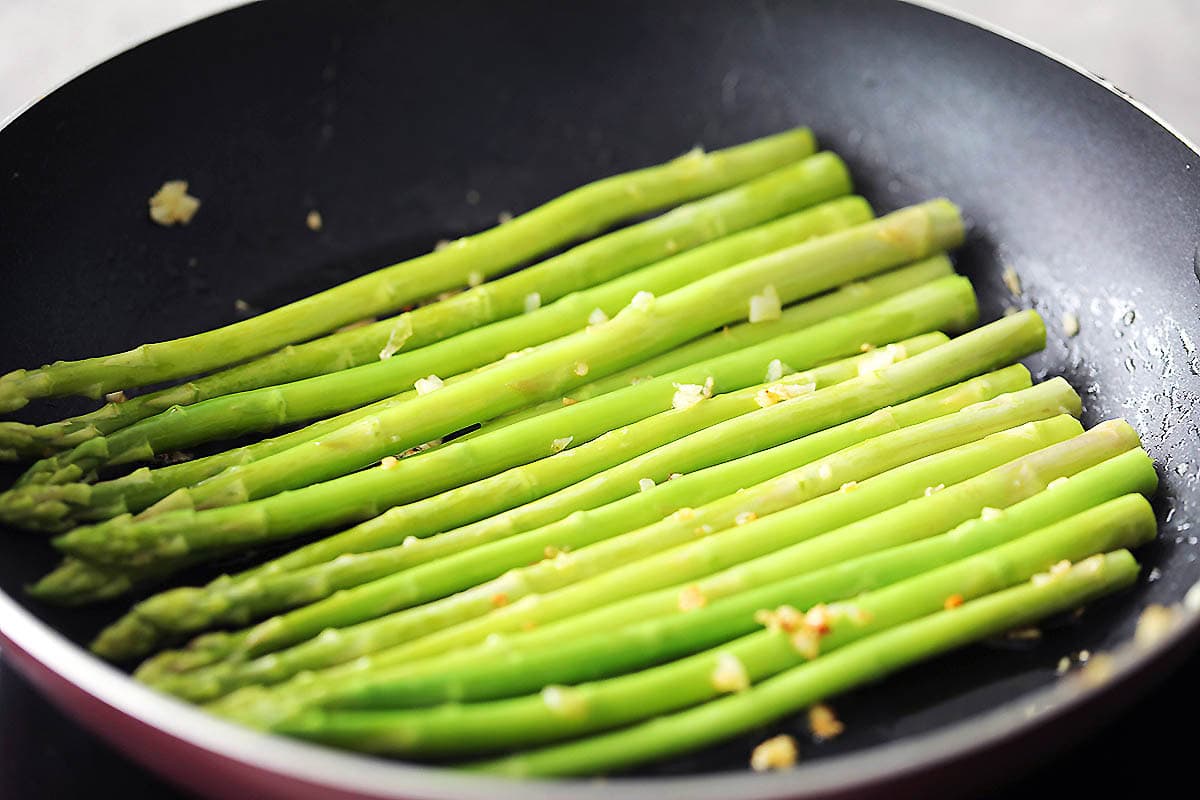 Asparagus and garlic in a skillet.