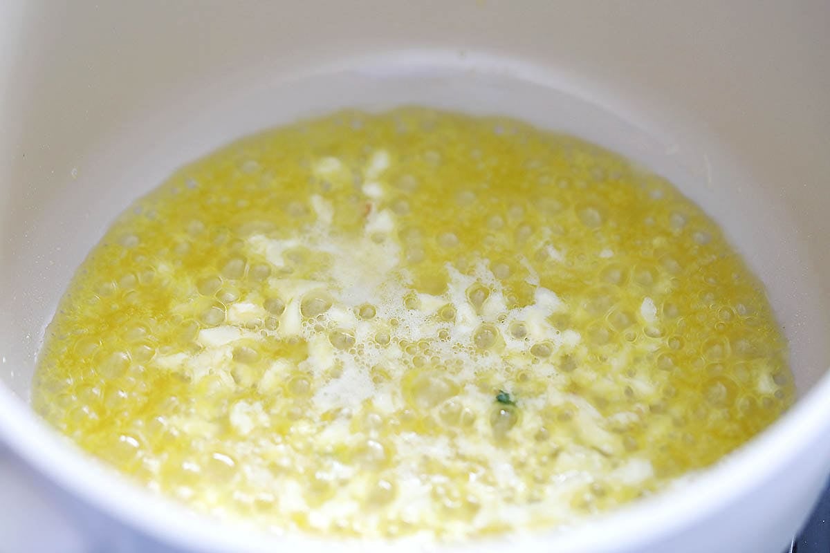 Melted butter and minced garlic in a pot.